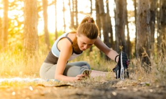 Wellness Wednesday: Effective Treatment for Hamstring Injuries Woman stretching her legs in a forest