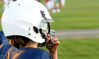 Wellness Wednesday: What To Do About a Concussion Child wearing a football helmet