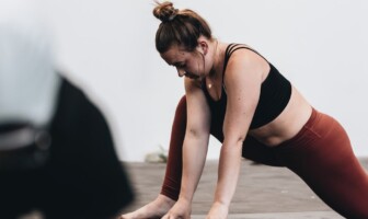 Wellness Wednesday: Walk Away From Hip Pain woman in black sports bra and yoga pants stretching her hip